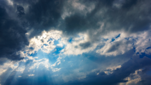 Light breaking through storm clouds, symbolizing clarity, hope, and leadership in times of uncertainty.